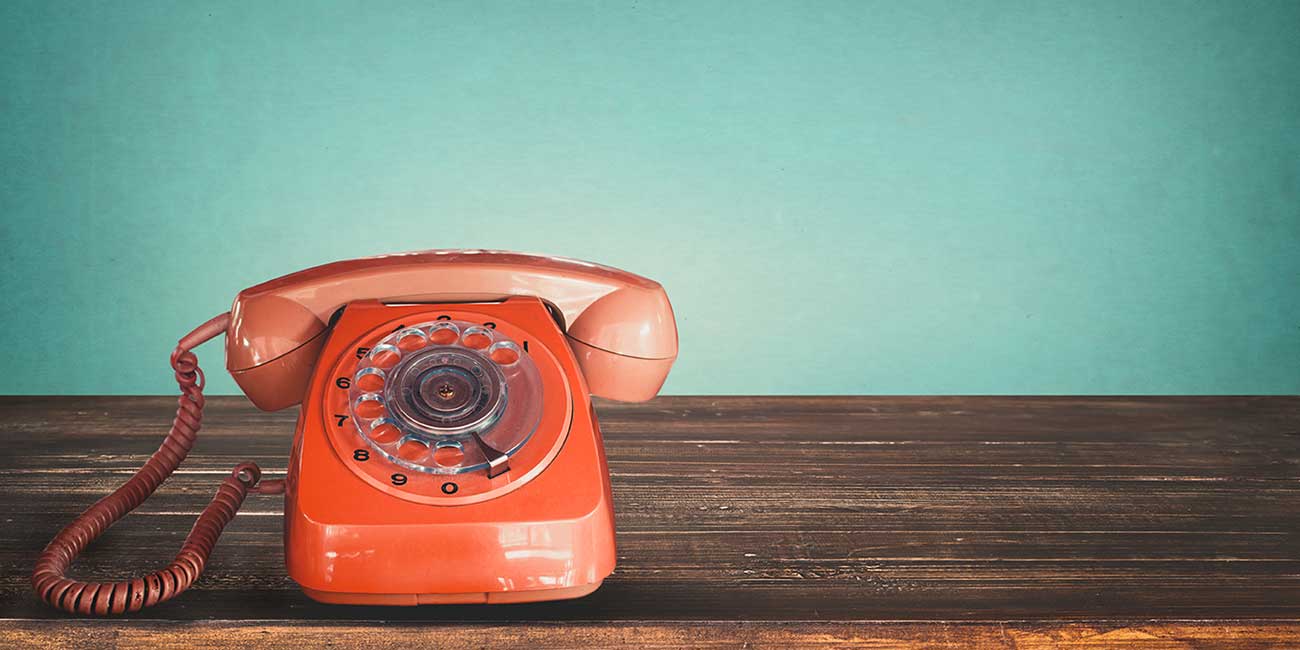 Rotes Telefon mit Wählscheibe das zeigt, warum die Telefon-Hotline noch lange nicht tot ist