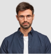 waist-up-portrait-handsome-serious-unshaven-male-keeps-hands-together-dressed-dark-blue-shirt-has-talk-with-interlocutor-stands-against-white-wall-sel