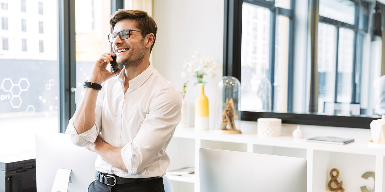 Geschäftsmann spart Kosten, weil er mit seinem Handy über die yuu Phone Cloud-Telefonanlage von yuutel telefoniert